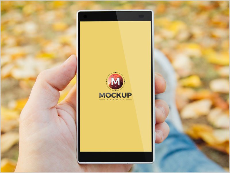 Free-Man-In-Park-Holding-Smartphone-Psd-Mockup